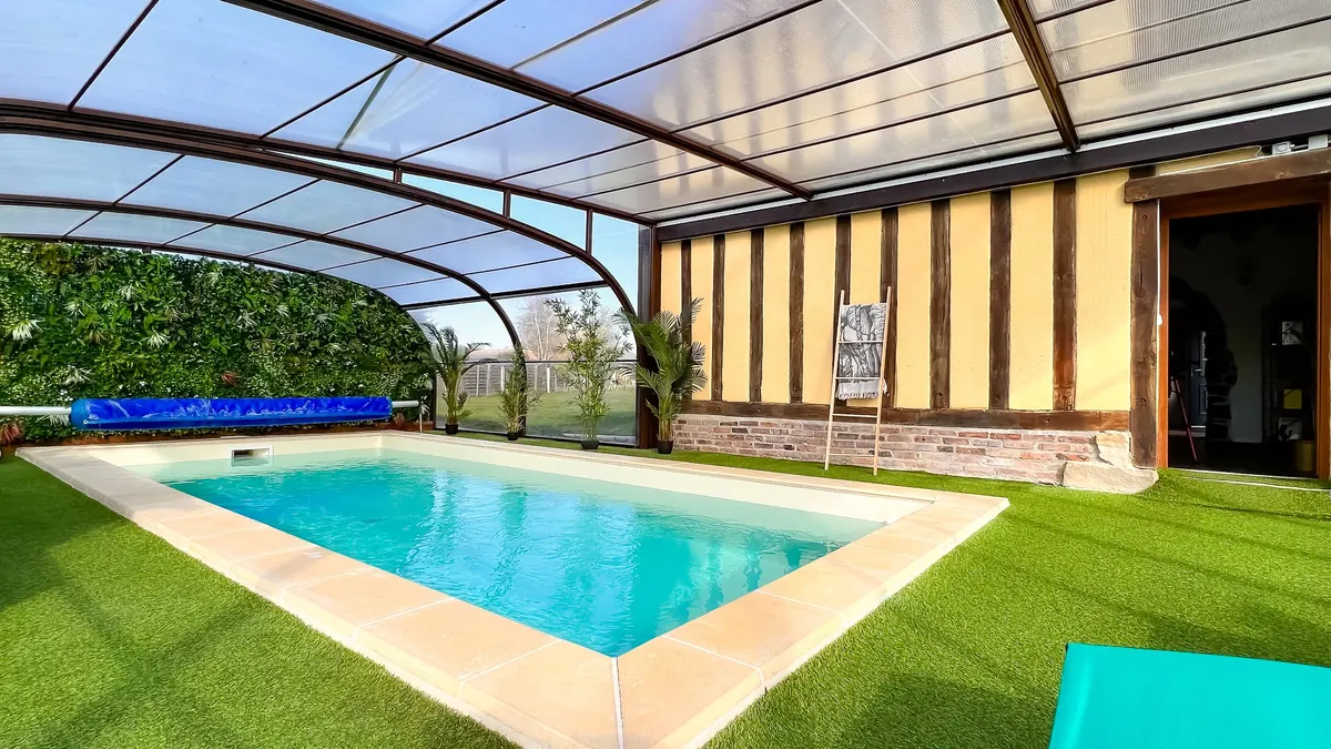 Piscine intérieure de 3 x 7 m sous abri, bordée de gazon